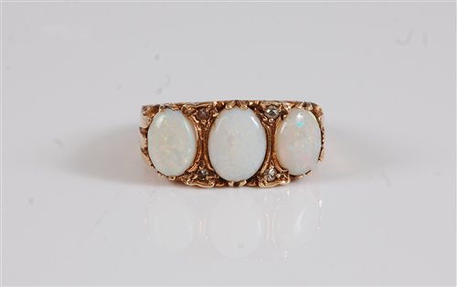 Lot 2594 - A 9ct opal and diamond ring, the three oval...