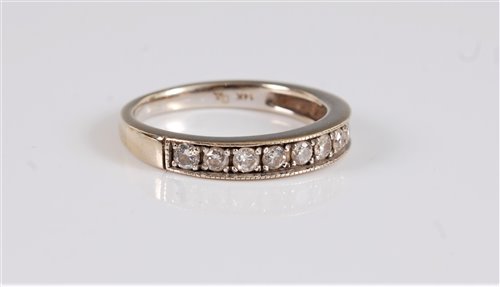 Lot 2595 - A 14k diamond half hoop eternity ring, the...