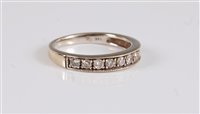 Lot 2595 - A 14k diamond half hoop eternity ring, the...