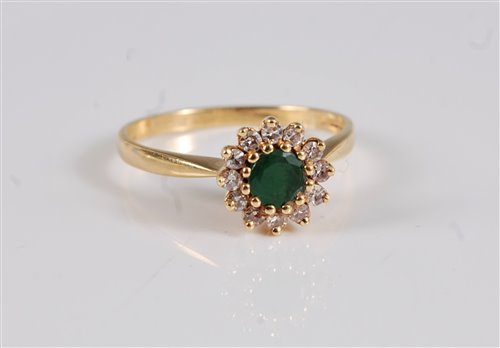 Lot 2663 - An 18ct emerald and diamond cluster ring, the...