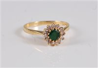 Lot 2663 - An 18ct emerald and diamond cluster ring, the...