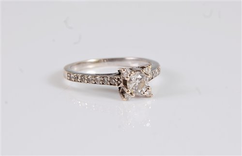 Lot 2623 - A diamond ring, the central round brilliant...