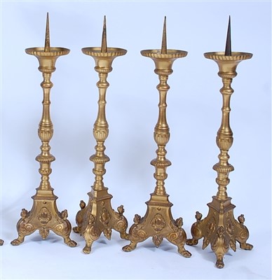 Lot 1384 - A set of four gilt brass alter sticks, in the...