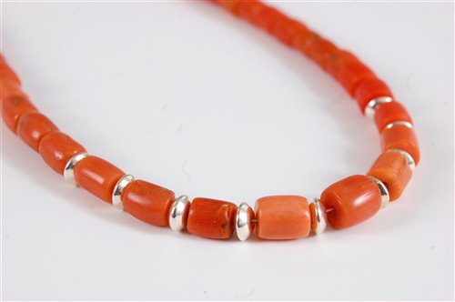 Lot 2570 - A coral bead necklace, the barrel shaped beads...