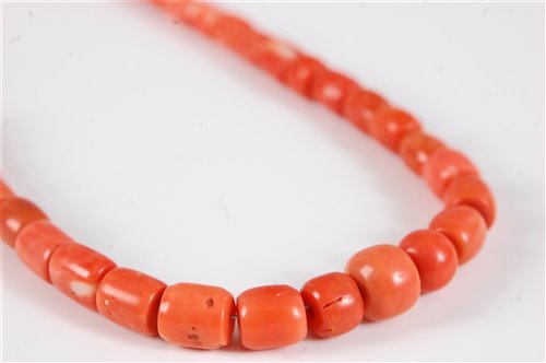 Lot 2571 - A coral bead necklace, the barrel shaped beads...