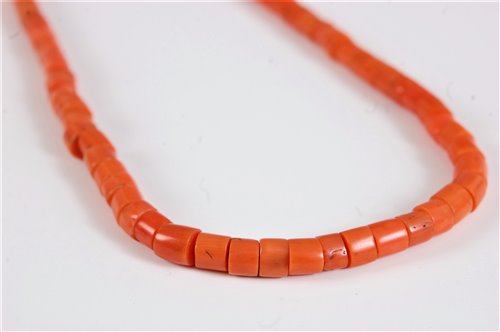 Lot 2572 - A coral bead necklace, the barrel shaped beads...
