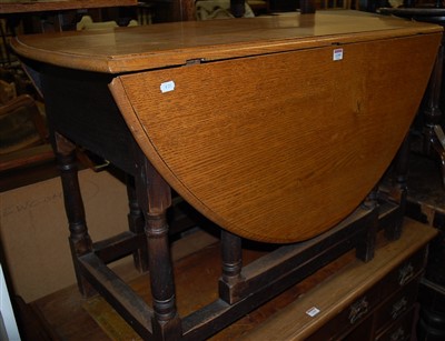 Lot 1259 - An early 20th century oak drop leaf dining...