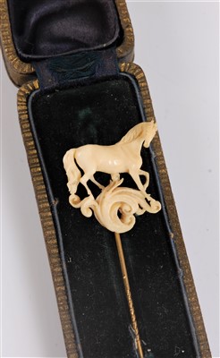 Lot 1325 - An ivory horse stick pin, the naturalistically...