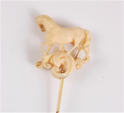 Lot 1325 - An ivory horse stick pin, the naturalistically...