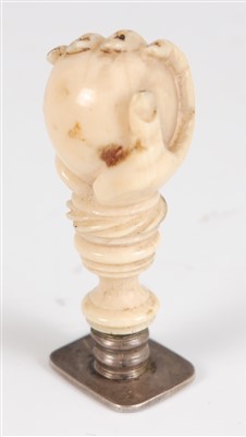 Lot 1355 - A 19th century carved ivory fist and ball seal,...