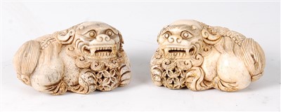 Lot 1419 - A pair of Chinese carved bone Foo Dogs, each...