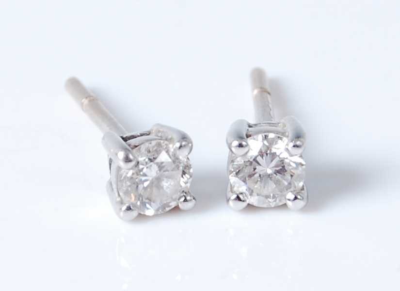 Lot 2569 - A pair of white metal diamond ear studs, the...