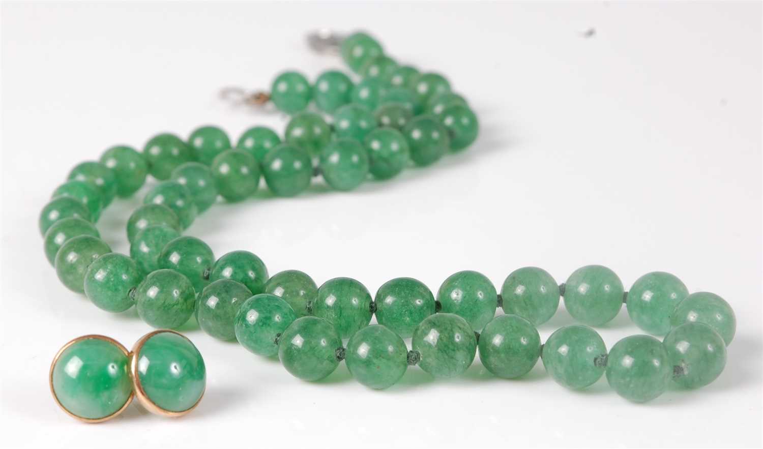 Lot 311 - A beaded and knotted green jade necklace, with...