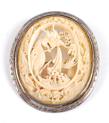 Lot 2503 A white metal oval carved ivory brooch