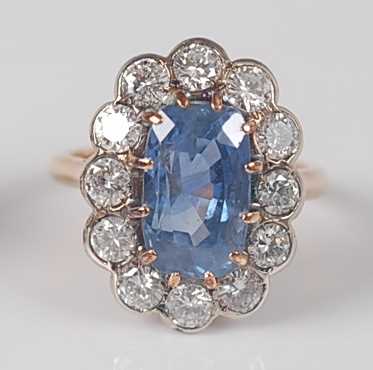 Lot 1174 - A sapphire and diamond oval cluster ring, claw...