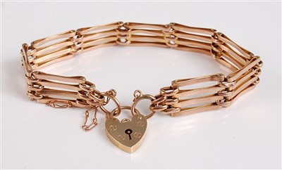Lot 2544 - A 9ct gold gatelink bracelet, with heart...
