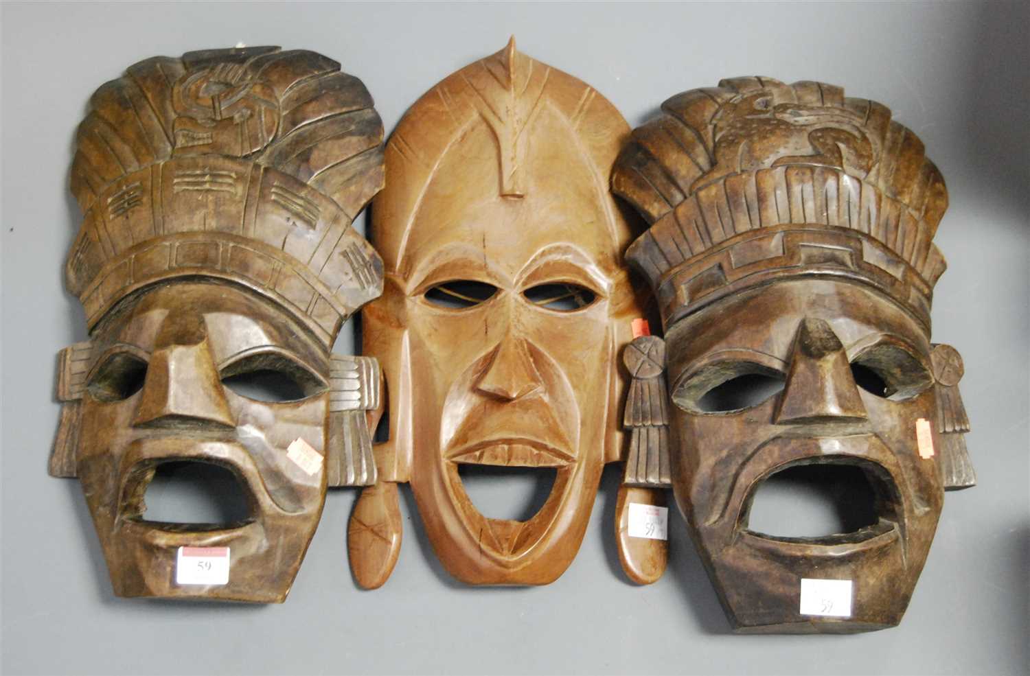 Lot 59 - A carved softwod tribal wall mask; together...