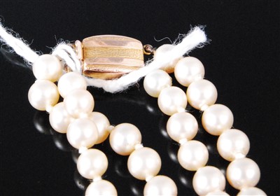 Lot 401 - A simulated and graduated pearl double string...