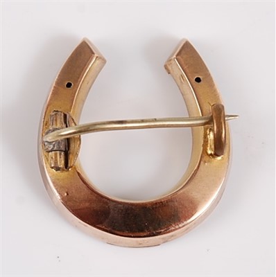 Lot 2556 - A yellow metal horseshoe brooch, the brooch...