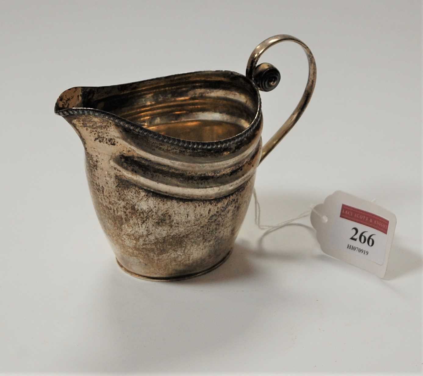 Lot 266 - A 19th century white metal cream jug of helmet...