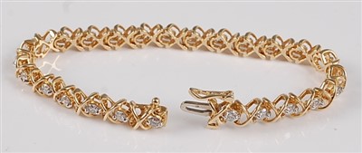 Lot 1219 - A yellow metal diamond line bracelet, the...