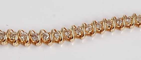 Lot 1220 - A yellow metal diamond line bracelet, the...