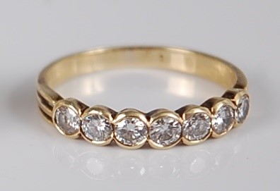 Lot 1202 - A yellow metal diamond half hoop ring,...