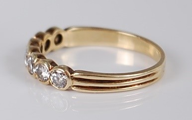 Lot 1202 - A yellow metal diamond half hoop ring,...