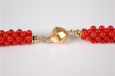 Lot 1199 - A beaded coral and yellow metal choker, the...