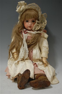 Lot 2057 - A large bisque head doll, having rolling blue...