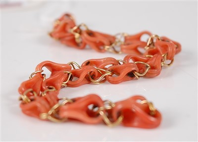 Lot 2674 - A coral and yellow metal necklace, the carved...
