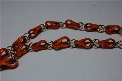 Lot 2674 - A coral and yellow metal necklace, the carved...