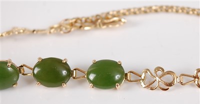Lot 2679 - A yellow metal and jade set bracelet, arranged...