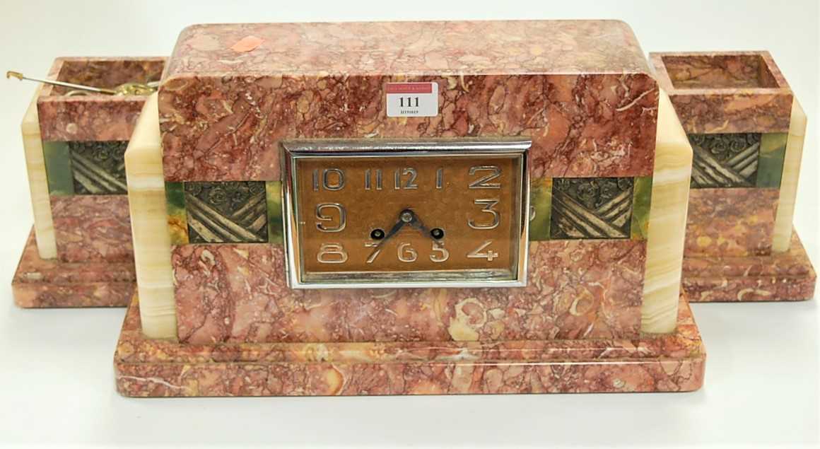 Lot 111 - An Art Deco rouge marble cased clock garniture,...
