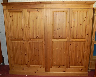 Lot 1112 - A large modern pine four door wardrobe, w.234cm