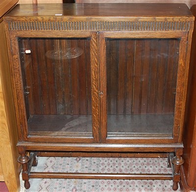 Lot 1376 - A 1930s oak double door glazed low bookcase,...