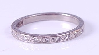 Lot 397 - A white metal diamond half-hoop eternity ring,...