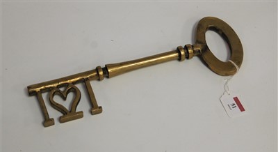 Lot 51 - A large decorative brass key, 34cm