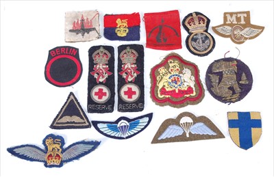 Lot 116 - A collection of loose cap badges, cloth badges and formation signs