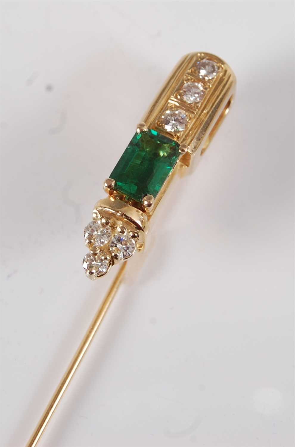 Lot 2216 - A yellow metal, emerald and diamond stick pin,...