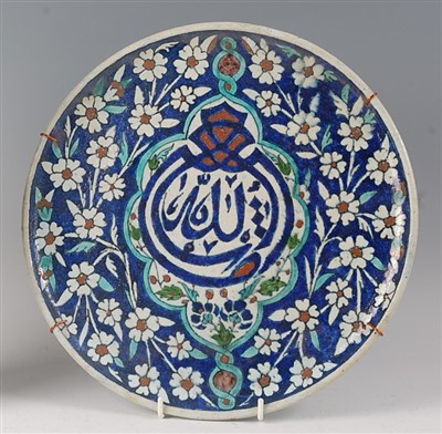 Lot 2332 - A Persian pottery small charger, underglaze...
