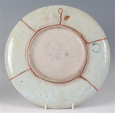 Lot 2332 - A Persian pottery small charger, underglaze...
