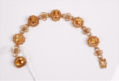 Lot 363 - A yellow metal and citrine set bracelet, the 6...