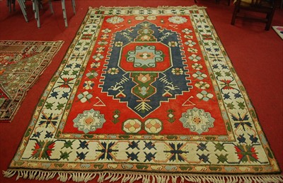 Lot 1147 - A Turkish woollen red ground rug, having...