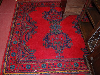 Lot 1152 - A Turkish woollen red ground square rug,...