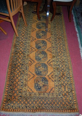 Lot 1153 - A Persian woollen rust ground Bokhara long...