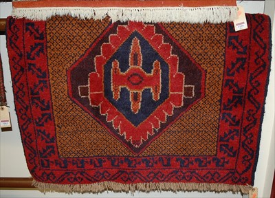 Lot 1160 - A small Persian woollen red ground rug, the...