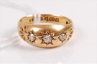 Lot 403 - An 18ct gold diamond three stone ring, the...