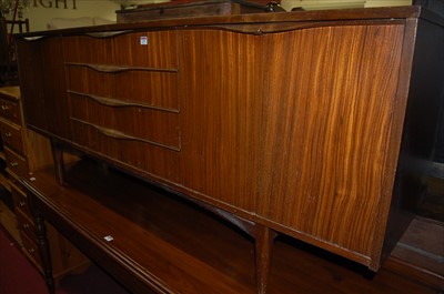 Lot 1237 - A 1960s British teak long sideboard, the four...