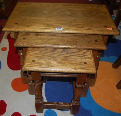 Lot 1263 - A moulded oak nest of three occasional tables,...